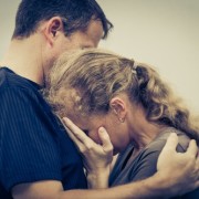 An image of a man hugging and comforting a woman who is upset.
