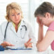 An image of a female doctor reviewing a medical chart with a mature female patient.