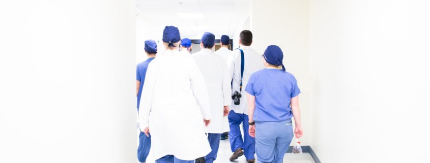 An image of doctors and nurses walking down a hospital hallway.