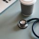 An image of a paper cup and stethoscope on a tray.