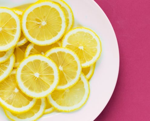 An image of a plate of lemon slices on a white plate.