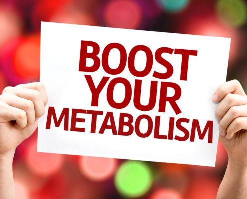 An image of hands holding a sign that reads, boost your metabolism.
