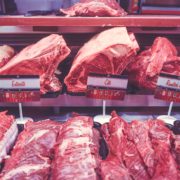 An image of shelves of different cuts of beef in a grocery store.