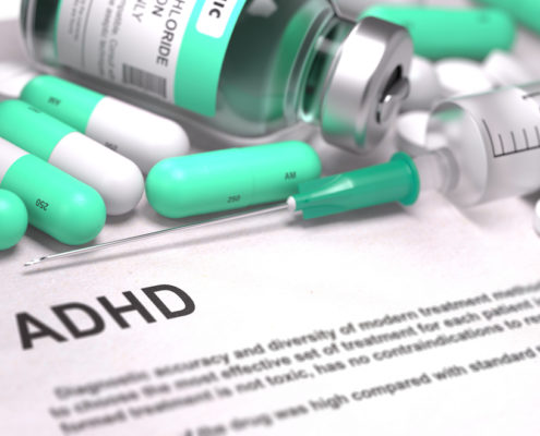 An image of light green pills, Injections, and Syringe on an ADHD medical report.