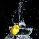 An image of a whole lemon dropped in a bowl of water.