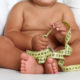 An image of an overweight child with a tape measure.