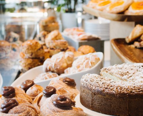 An image of pastry, cakes, cookies and other goodies at a diner.