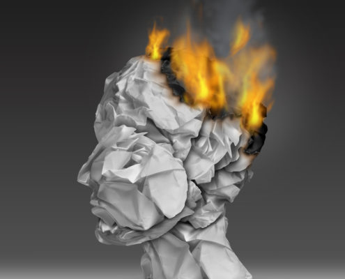 An image of a paper sculpture of a human face and neck with flames coming out of the brain area.