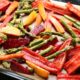An image of a baking sheet with bell peppers and asparagus.
