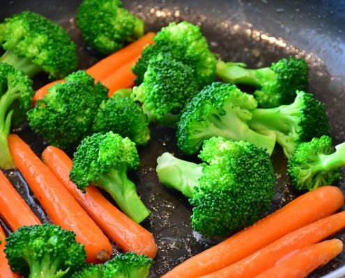 An image of a plate of cooked broccoli and carrots.