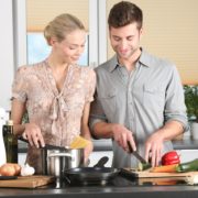 An image of a young man and woman cooking in the kitchen together.