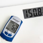An image of a glucose monitor on a bathroom scale.