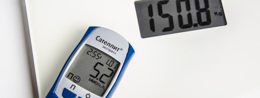 An image of a glucose monitor on a bathroom scale.