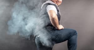 An image of a man with smoke billowing out behind him symbolizing a fart.