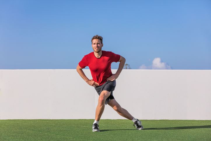 An image of a fit man performing a curtsy lunge.