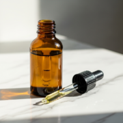 Retinol serum bottle with dropper on marble surface, best retinol for women over 60