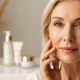Mature woman with healthy glowing skin applying dark spot treatment